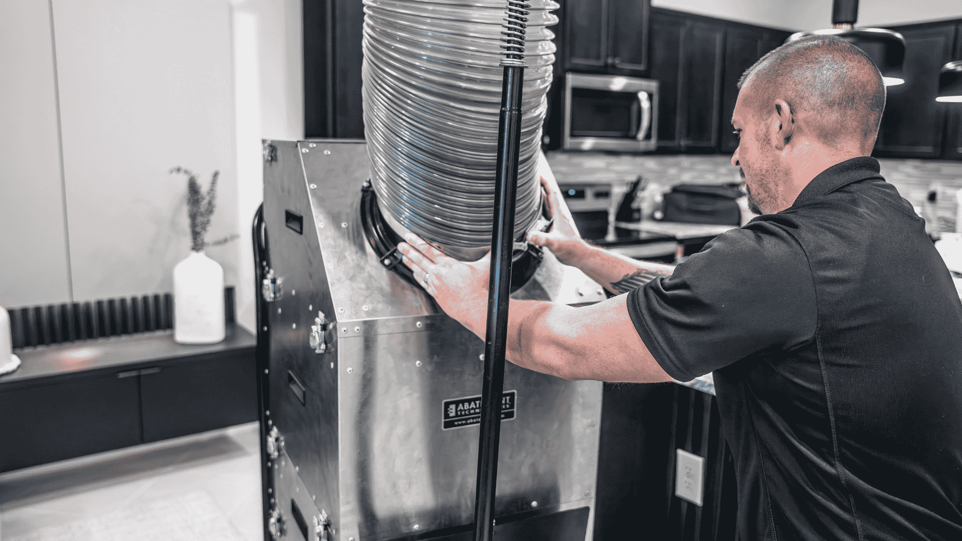 Air Titans specialist attaches a flexible duct hose to a high-capacity cleaning machine, demonstrating duct replacement and airflow testing.