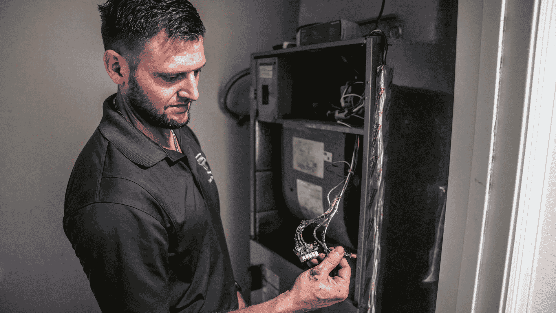 Air Titans professional inspects the interior of an HVAC cabinet, examining wiring and ductwork before applying thermal insulation.