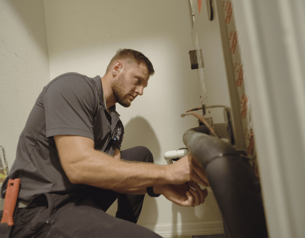 Air Titan technician inspecting air conditioning unit components in a Tampa home