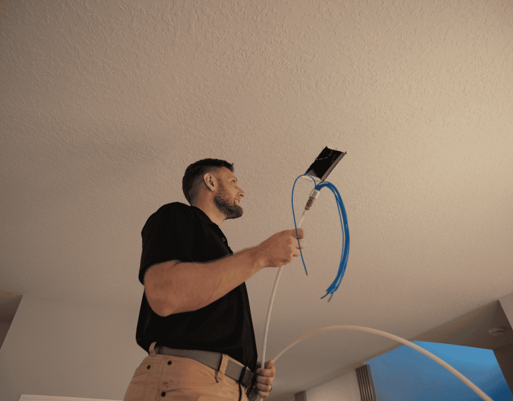 Air Titans technician applying insulation material around HVAC duct opening in a Tampa residence